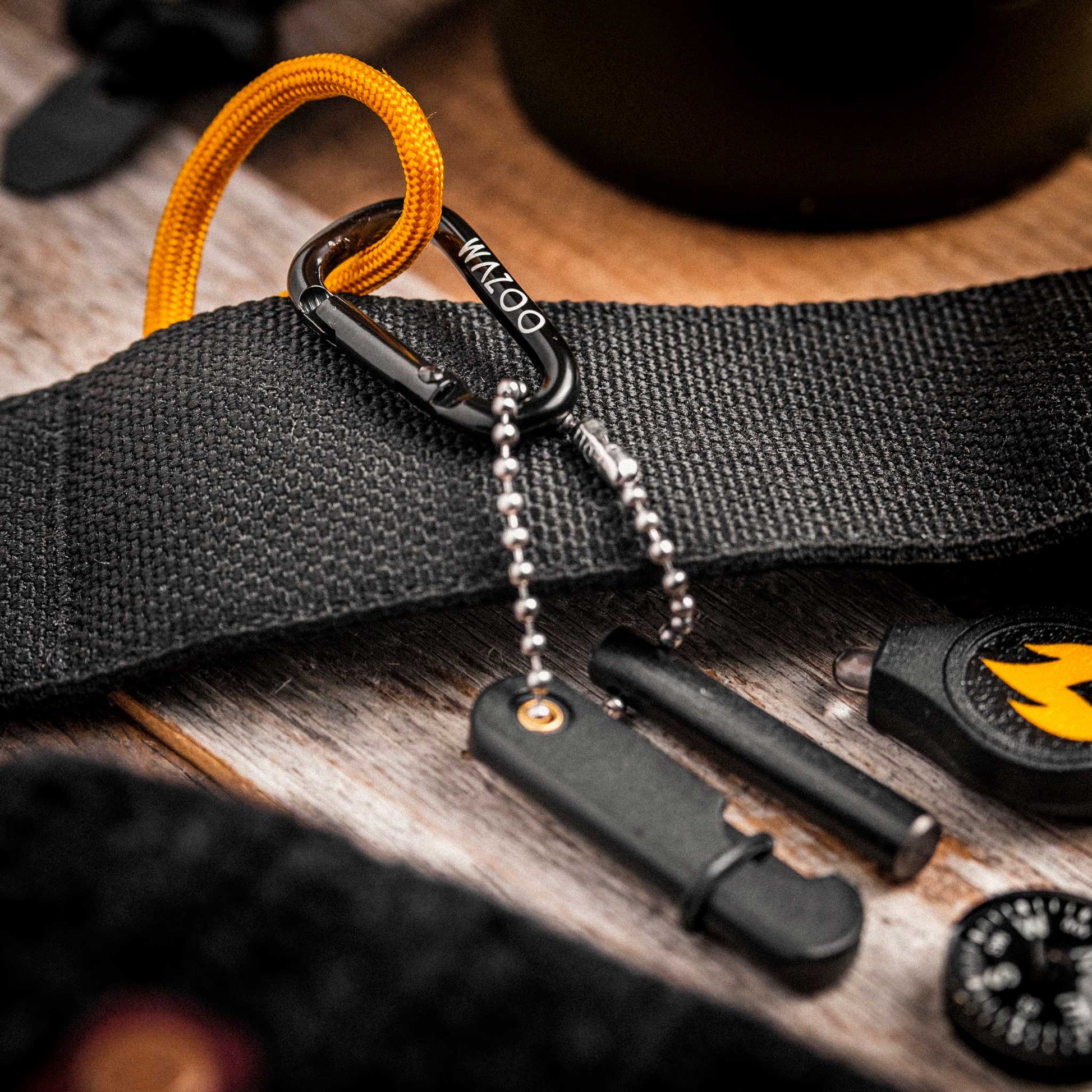 Black belt with carabiner and tools on a wooden surface