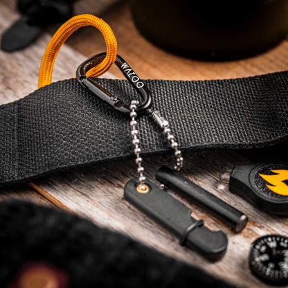 Black belt with carabiner and tools on a wooden surface
