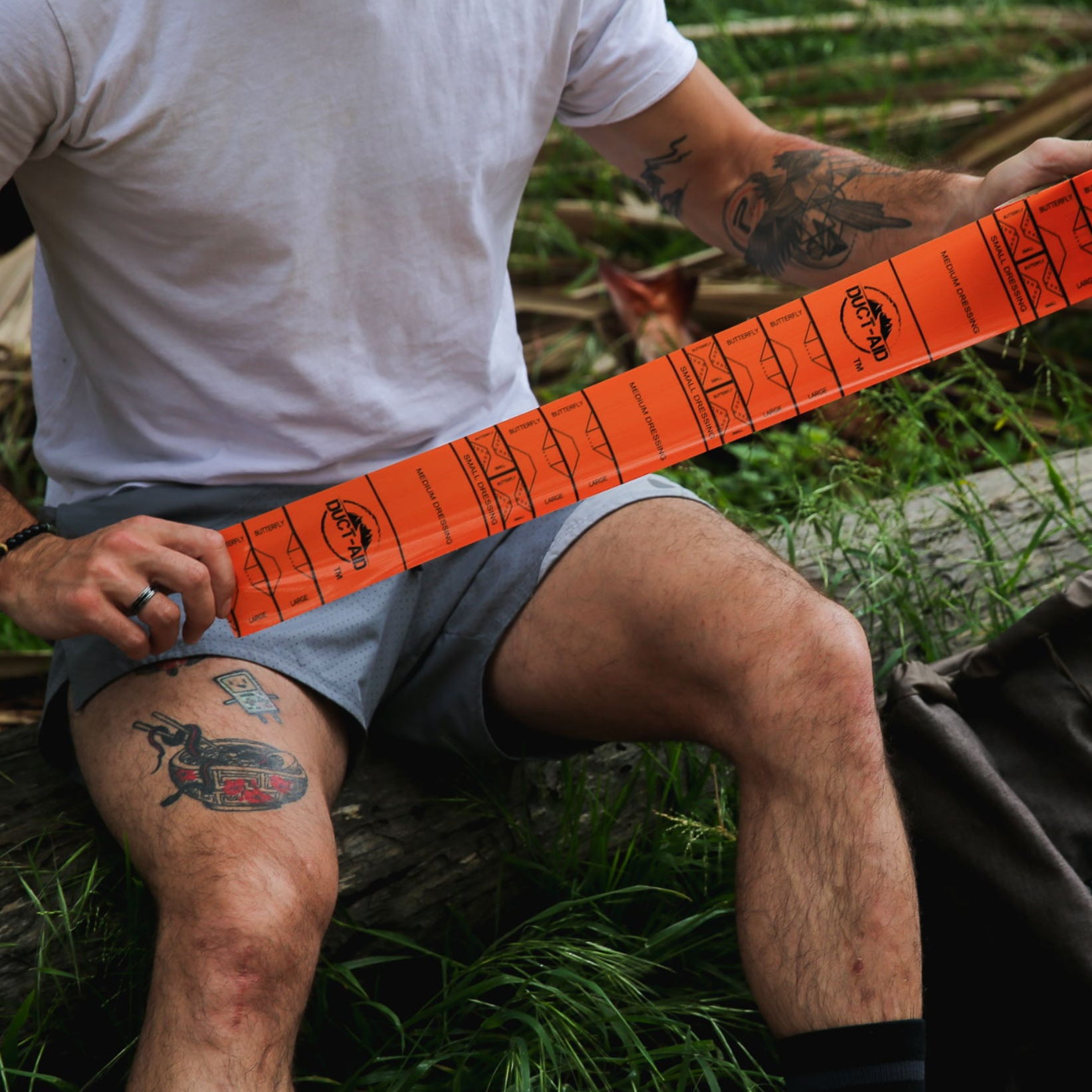 Person holding an orange measuring tape outdoors